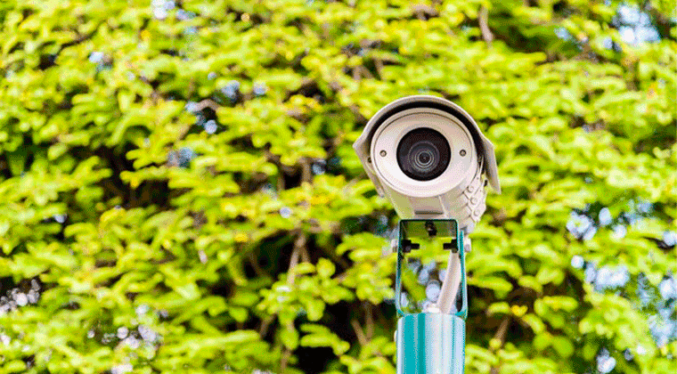 Um close de uma câmera em cima de um poste