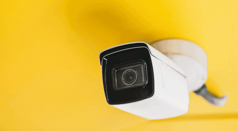 Uma câmera montada na lateral de uma parede amarela
