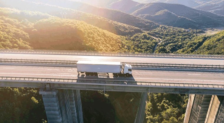 Imagem panorâmica de um caminhão em trânsito em uma ponte
