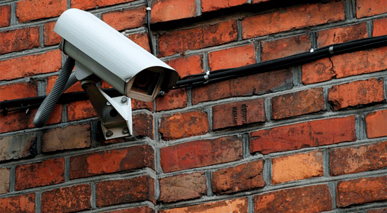 Uma câmera de segurança fixada em uma parede de tijolos