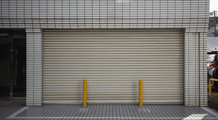 Uma porta de garagem fechada com postes amarelos na frente