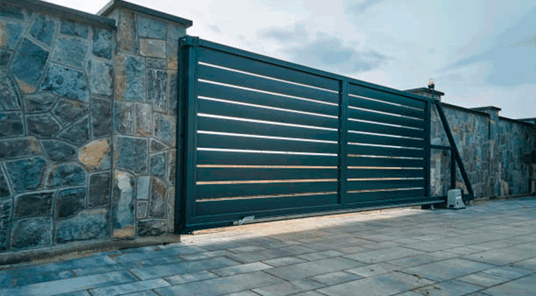 Um muro de pedra com um portão automatizado deslizante