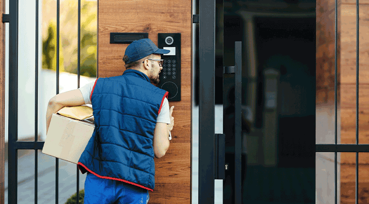 Um homem de colete azul está abrindo uma porta